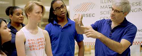 Magnetic Fields screen shot of the group of students at an I-MRSEC open house in MRL. To the right is an actual I-MRSEC senior research scientist, Julio Soares, who is explaining a principle about his research to the students. (Image courtesy of John Isberg.)